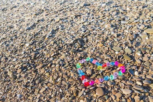 Cam çakıl deniz kıyısında parlak renkli kalp