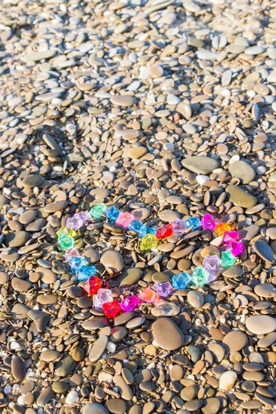 Cam çakıl deniz kıyısında parlak renkli kalp