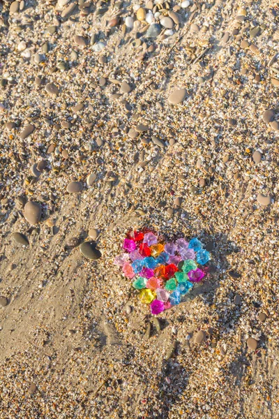 Buntes Herz aus Glassteinen am Ufer des Meeres — Stockfoto