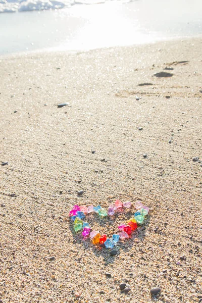 Cam çakıl deniz kıyısında parlak renkli kalp