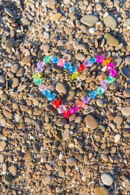 Cam çakıl deniz kıyısında parlak renkli kalp