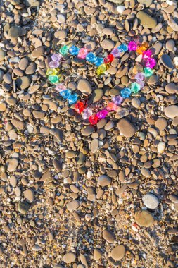 Cam çakıl deniz kıyısında parlak renkli kalp