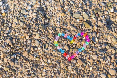 Cam çakıl deniz kıyısında parlak renkli kalp