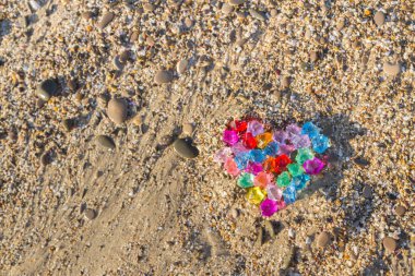 Cam çakıl deniz kıyısında parlak renkli kalp