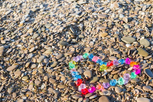 Coração brilhantemente colorido de seixos de vidro na costa do mar — Fotografia de Stock