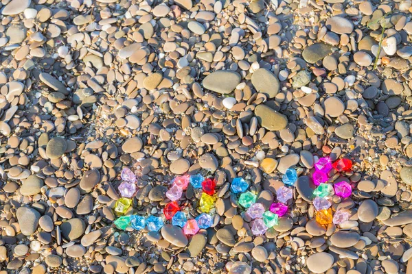 The inscription love of colored glass stones on sea rocks — Stock Photo, Image