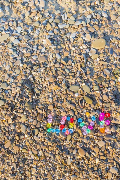 The inscription love of colored glass stones on sea rocks — Stock Photo, Image