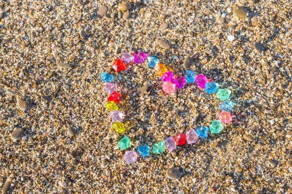 Brightly colored heart of glass pebbles on the sea shore — Stock Photo, Image