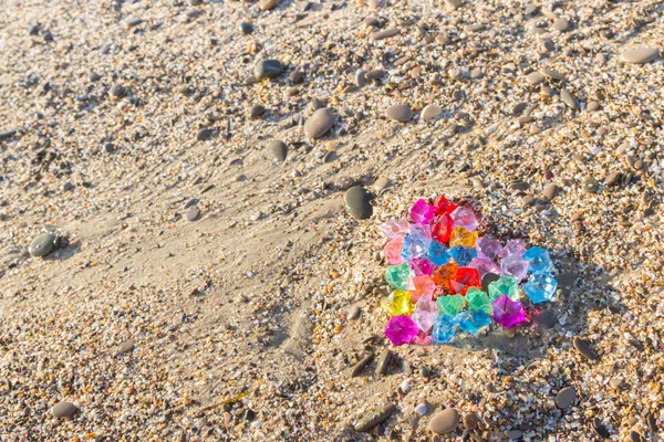 Brightly colored heart of glass pebbles on the sea shore — Stock Photo, Image