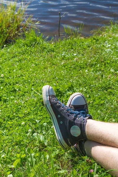 Jeans-Turnschuhe im Sommer auf grünem Gras — Stockfoto