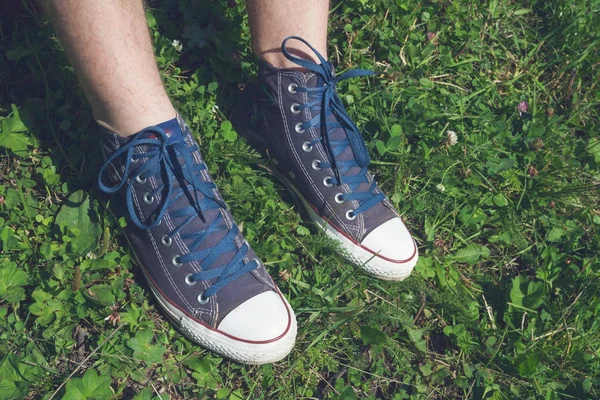 Denim sneakers på grönt gräs på sommaren — Stockfoto