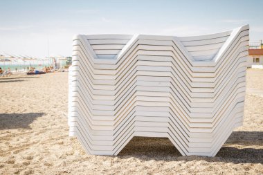 Beyaz sahilde şezlong yığılmış