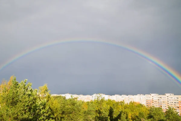 A bright rainbow over the city in the fall