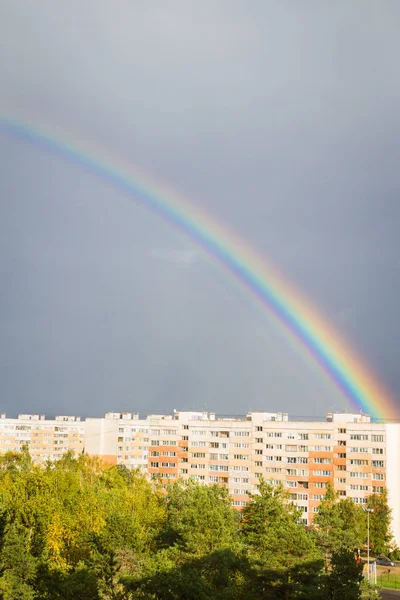 Un arco iris brillante sobre la ciudad en el otoño — Foto de Stock