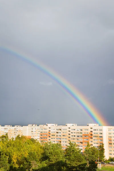 Un arco iris brillante sobre la ciudad en el otoño — Foto de Stock