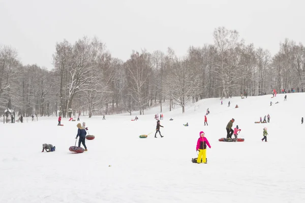 Zimowe zabawy na rolkach wzgórza ze śniegiem na serniki sanie i sno — Zdjęcie stockowe