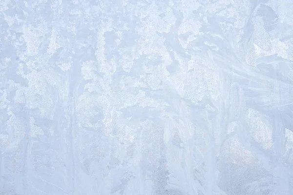 Frostige Wintermuster auf dem gefrorenen Eisfenster — Stockfoto