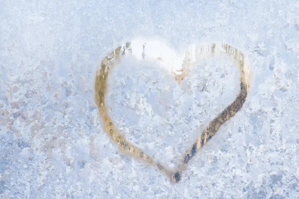 Hjärtat på en frostig vinter i de frysta mönster av is fönster — Stockfoto