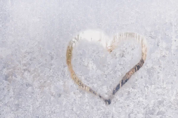 Herz an einem frostigen Winter in den gefrorenen Mustern des Eisfensters — Stockfoto