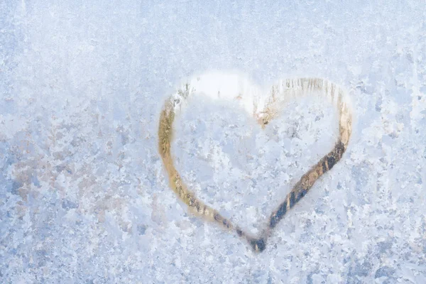 Heart on a frosty winter in the frozen patterns of ice window — Stock Photo, Image