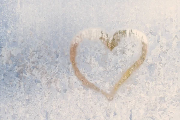 Hjärtat på en frostig vinter i de frysta mönster av is fönster — Stockfoto