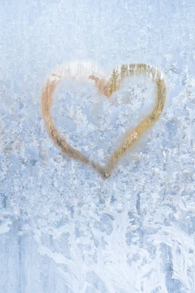 Heart on a frosty winter in the frozen patterns of ice window Stock Image