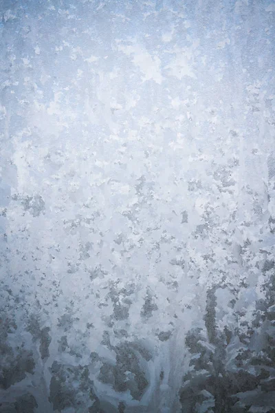 Frostige Wintermuster auf dem gefrorenen Eisfenster — Stockfoto