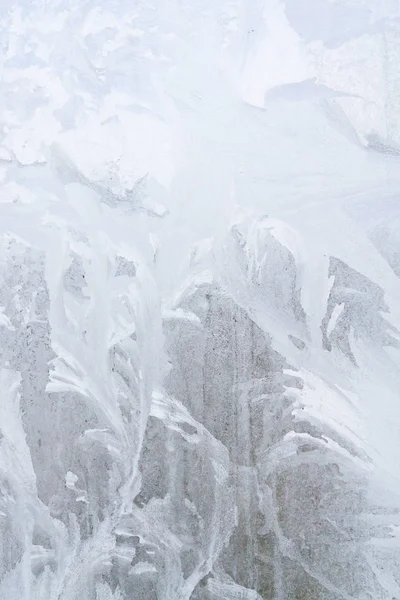 Frostige Wintermuster auf dem gefrorenen Eisfenster — Stockfoto