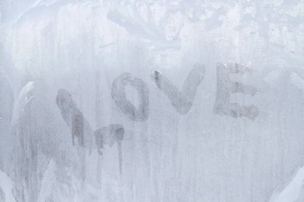 Inscrição de amor na janela congelada em padrões de inverno em Wint — Fotografia de Stock