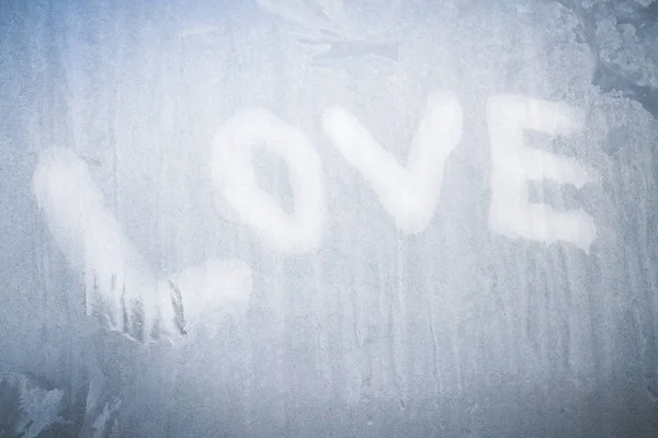 Надпись любви на замороженном окне зимой зимой — стоковое фото