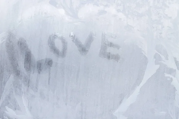 Inscrição de amor na janela congelada em padrões de inverno em Wint — Fotografia de Stock