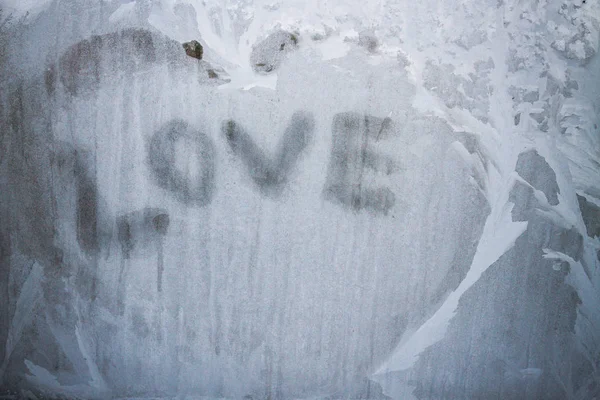 Надпись любви на замороженном окне зимой зимой — стоковое фото