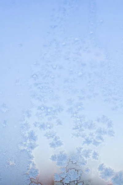 Frostige Wintermuster auf dem gefrorenen Eisfenster — Stockfoto
