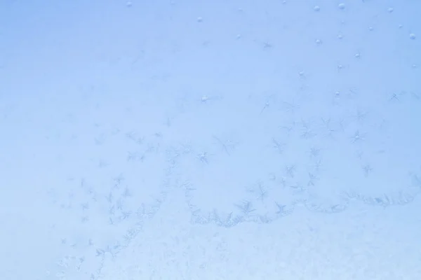 Frostige Wintermuster auf dem gefrorenen Eisfenster — Stockfoto