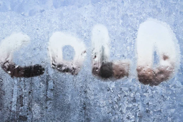 Die Inschrift ist kalt auf einem gefrorenen Fenster mit Mustern — Stockfoto