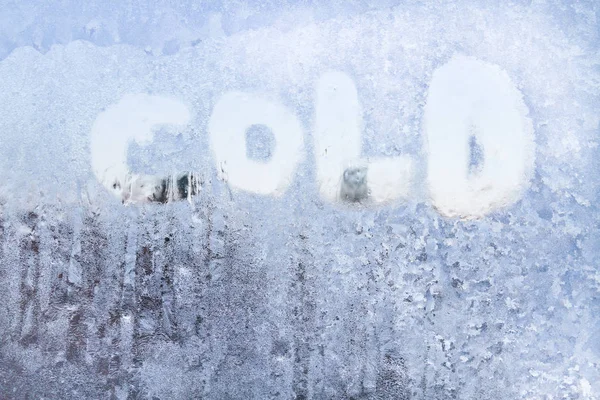 Desenleri ile dondurulmuş bir pencere üzerinde yazıt soğuktur — Stok fotoğraf