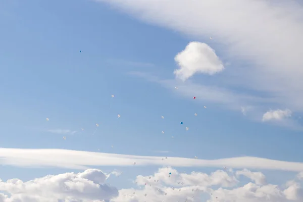 Balões coloridos voam no céu azul da primavera com nuvens brancas — Fotografia de Stock