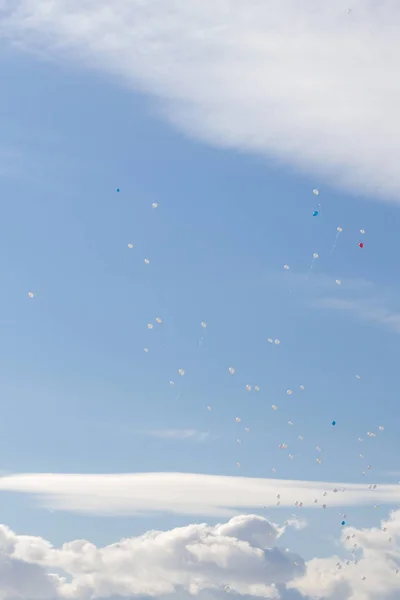 Kolorowe balony latają w niebo niebieski wiosna z białe chmury — Zdjęcie stockowe