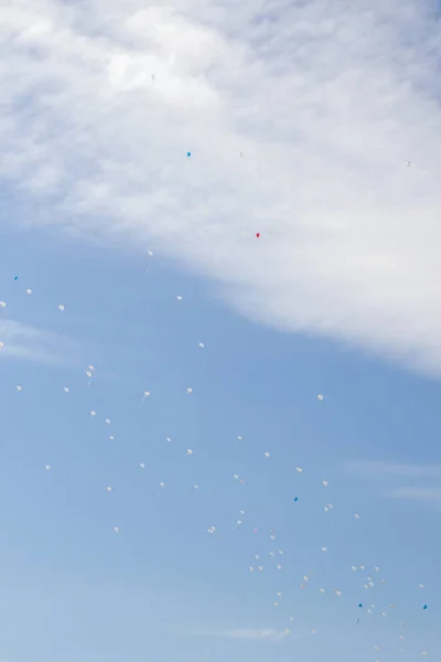 Kolorowe balony latają w niebo niebieski wiosna z białe chmury — Zdjęcie stockowe