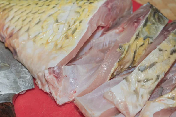 Limpeza de carpa de peixe fresco de escamas com uma faca especial — Fotografia de Stock