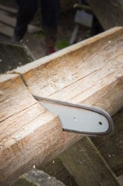 Günlükleri elektrikli testereyle yakacak odun için kesmek