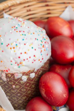 Bir hasır sepette boyalı tavuk yumurtası ile Paskalya bahar kek