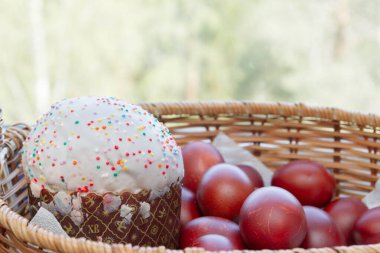 Bir hasır sepette boyalı tavuk yumurtası ile Paskalya bahar kek