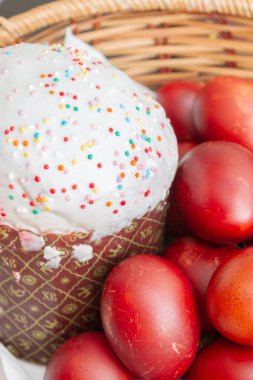Bir hasır sepette boyalı tavuk yumurtası ile Paskalya bahar kek