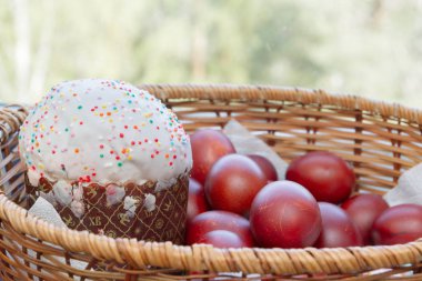 Bir hasır sepette boyalı tavuk yumurtası ile Paskalya bahar kek