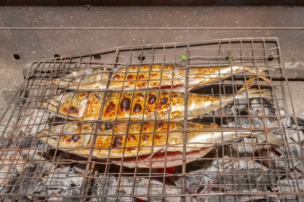 Жареная копченая золотая макрель рыба на улице поздно ночью — стоковое фото