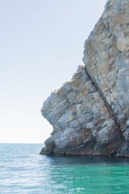 Yazın güneşli bir günde kumsalda dağlar ve kayalar