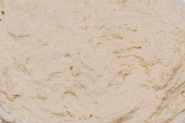 Kneading dough with flour on a wooden table at home