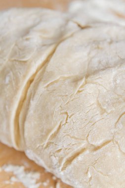 Prepared kneaded dough on a wooden table at home