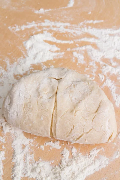 Prepared kneaded dough on a wooden table at home